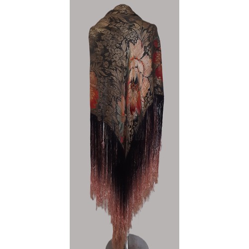 685 - An Art Deco lamé fringed evening shawl woven with large flowers on a black ground, with ombre dyed t... 