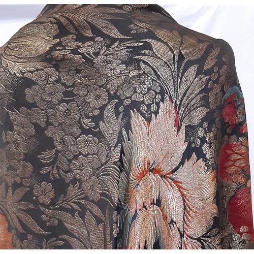 685 - An Art Deco lamé fringed evening shawl woven with large flowers on a black ground, with ombre dyed t... 