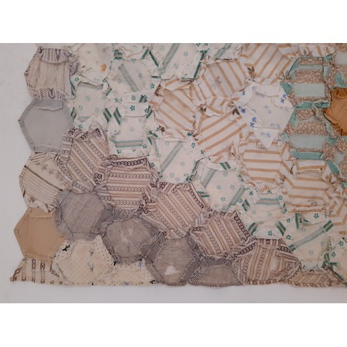 696 - A large vintage patchwork  panel/ quilt composed of hexagon patches of various printed cottons formi... 