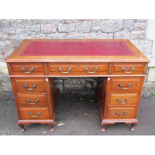 1305 - A Georgian style kneehole twin pedestal desk, with inset leather top over an arrangement of eight dr... 