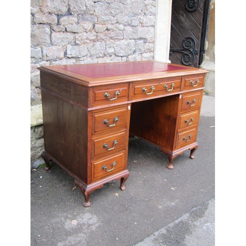 1305 - A Georgian style kneehole twin pedestal desk, with inset leather top over an arrangement of eight dr... 