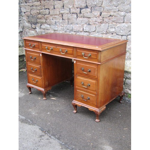 1305 - A Georgian style kneehole twin pedestal desk, with inset leather top over an arrangement of eight dr... 