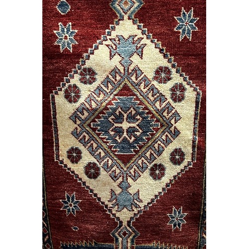 1628 - A Turkoman style rug with geometric patterns on a red ground, 200cm x 125cm, together with a Kazak t... 