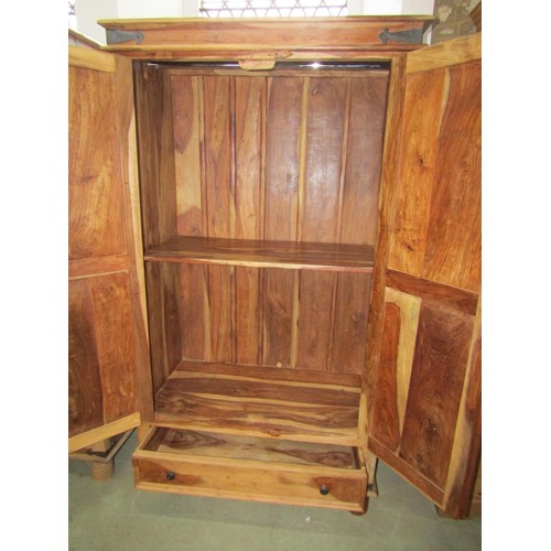 1284 - An Indian hardwood wardrobe enclosed by a pair of panelled doors over a long drawer, 180cm high x 10... 