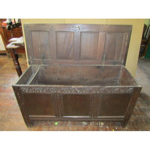 1362 - An 18th century oak plank coffer with panelled frame work and carved frieze, 71cm high x 137cm wide ... 