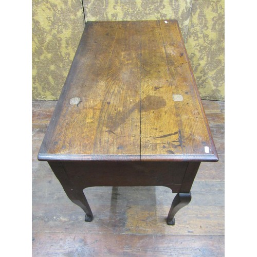 1364 - A Georgian oak side table with three drawers over a central kneehole on shaped supports, 105cm wide