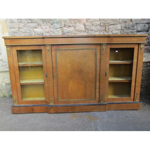 1375 - A Victorian walnut breakfront credenza enclosed by a central solid door, flanked by further glass do... 