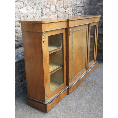 1375 - A Victorian walnut breakfront credenza enclosed by a central solid door, flanked by further glass do... 