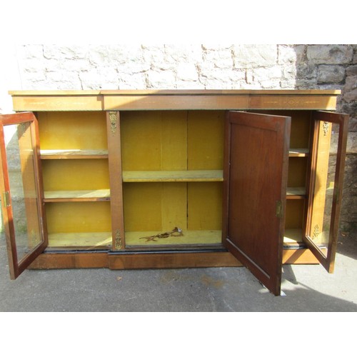 1375 - A Victorian walnut breakfront credenza enclosed by a central solid door, flanked by further glass do... 