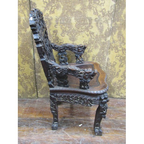 1411 - A 19th century carved Chinese hardwood elbow chair, profusely decorated with dragons, characters, sc... 