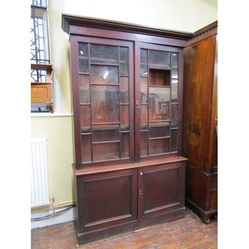 1425 - A 19th mahogany shop cabinet, the upper section with glazed and panelled doors over further panelled... 