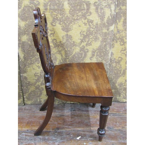 1453 - A regency mahogany hall chair with carved and shaped back, geometric detail and military figure