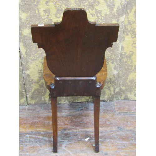 1453 - A regency mahogany hall chair with carved and shaped back, geometric detail and military figure