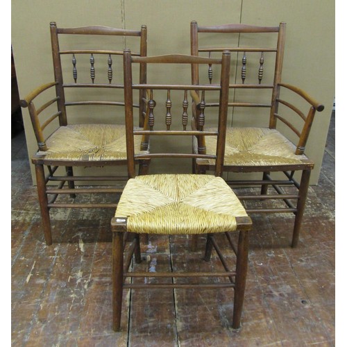 1456 - A pair of Sussex style armchairs in beechwood with rush seats, together with a matching single chair