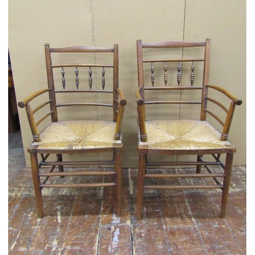 1456 - A pair of Sussex style armchairs in beechwood with rush seats, together with a matching single chair