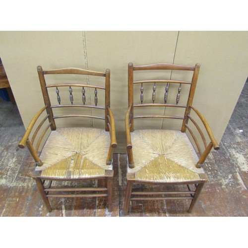 1456 - A pair of Sussex style armchairs in beechwood with rush seats, together with a matching single chair