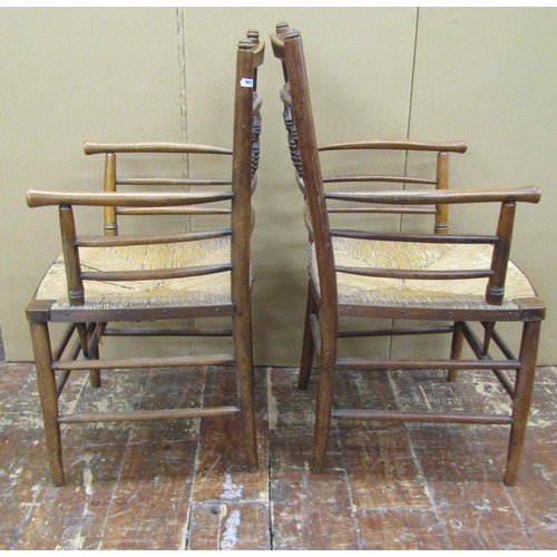 1456 - A pair of Sussex style armchairs in beechwood with rush seats, together with a matching single chair