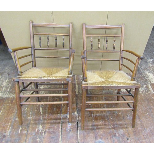 1456 - A pair of Sussex style armchairs in beechwood with rush seats, together with a matching single chair