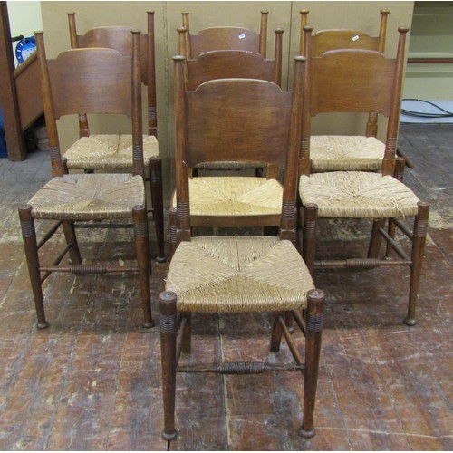 1458 - A set of nine (7+2) Arts & Crafts dining chairs by William Birch in oak with panelled back and rush ... 