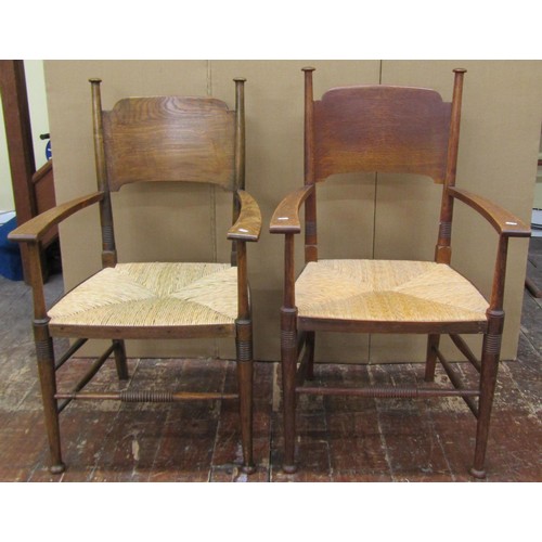 1458 - A set of nine (7+2) Arts & Crafts dining chairs by William Birch in oak with panelled back and rush ... 