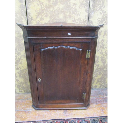 1465 - A small Georgian oak hanging corner cupboard with panelled door