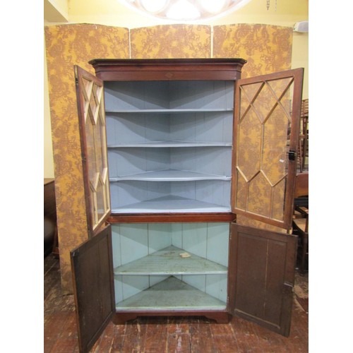 1473 - A late Georgian oak corner cupboard freestanding, the upper section with astragal glazed panel doors... 