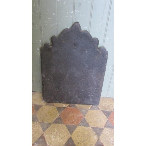 1063 - A small but heavy cast iron fire back of stepped arched form with raised relief detail, 60cm high x ... 