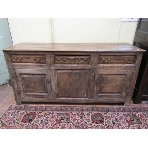 1348 - A Georgian oak dresser enclosed by two panelled doors and three drawers, with brass fittings, 87cm h... 