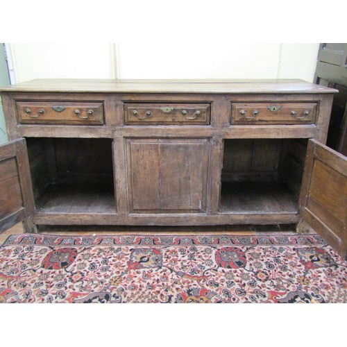 1348 - A Georgian oak dresser enclosed by two panelled doors and three drawers, with brass fittings, 87cm h... 