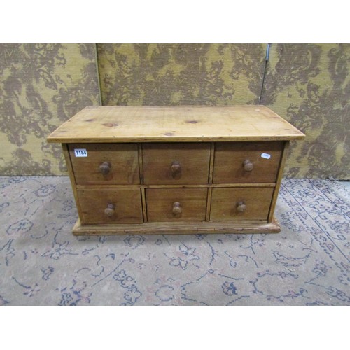 1184 - A small stripped pine counter top chest of six drawers with mahogany fronts, 33cm high x 65cm x 35cm