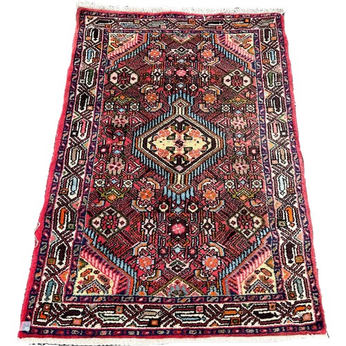 1610 - A small Persian rug with a lozenge shaped central medallion and stylised flowers, 125cm x 78cm appro... 