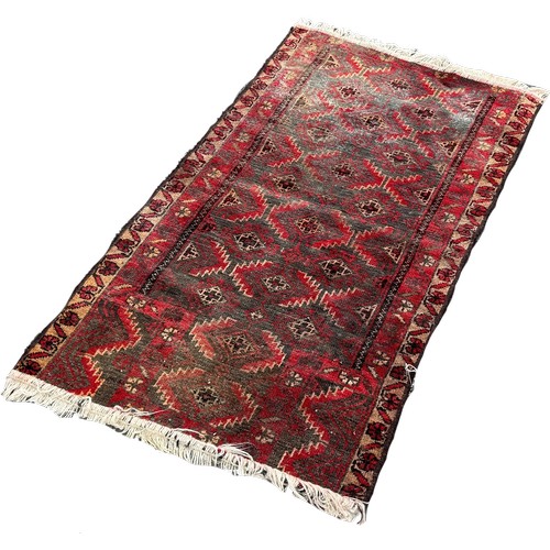 1612 - An old Middle Eastern rug with alternating rows of geometric medallions 135cm x 80 approximately