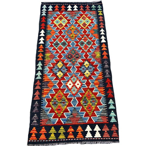 1615 - A Chobi Kilim runner with interlocking stepped lozenges 143cm x 67cm approximately