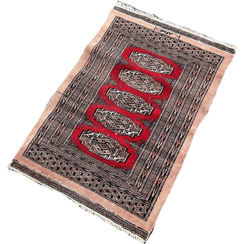 1622 - A Small Afghan rug with four medallions on a red ground bears a signature 100cm x 65cm approximately