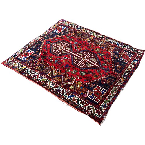 1631 - A small Afghan rug with an interlocking extended lozenge on a red ground, 150cm x 120cm