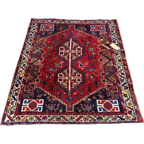 1631 - A small Afghan rug with an interlocking extended lozenge on a red ground, 150cm x 120cm