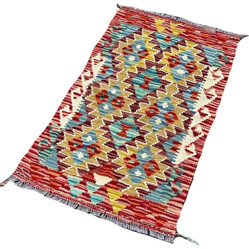 1632 - A Chobi Kilim mat with interlocking stepped medallions, 94cm x 56cm approximately