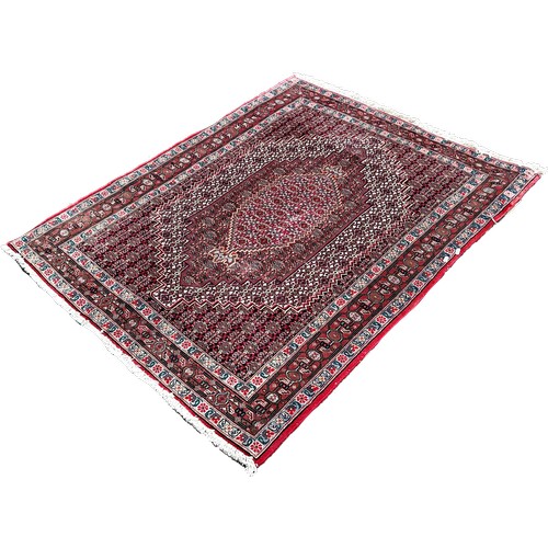 1633 - A Persian carpet with a radiating all over floral pattern, 150cm x 120cm approximately.