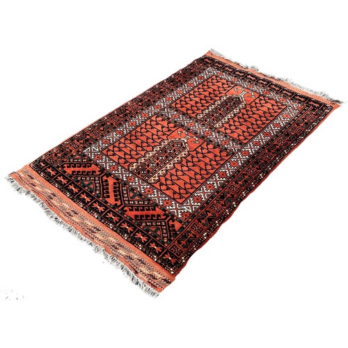 1635 - A Persian rug with mirrored geometric designs on a rusty red ground, 160cm x 55cm approximately