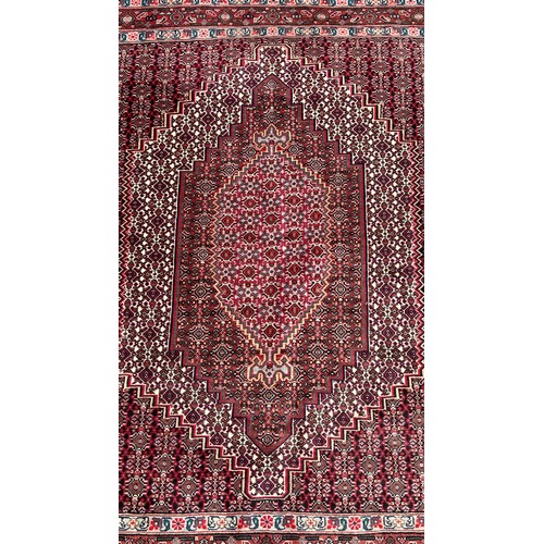 1633 - A Persian carpet with a radiating all over floral pattern, 150cm x 120cm approximately.