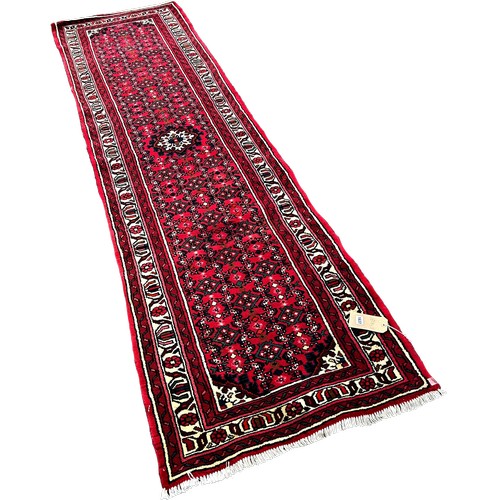 1637 - A Persian runner with a central panel with an all over field of stylised flowers, 310cm x 80cm appro... 