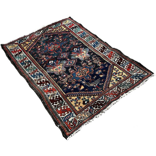 1645 - A small Persian rug with a central panel interspersed with geometric patterns on a blue ground, 140c... 