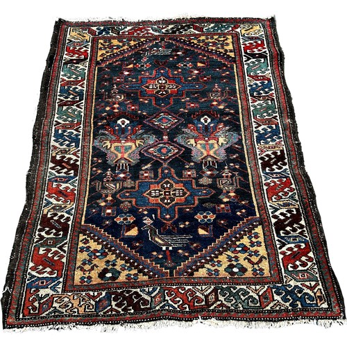 1645 - A small Persian rug with a central panel interspersed with geometric patterns on a blue ground, 140c... 