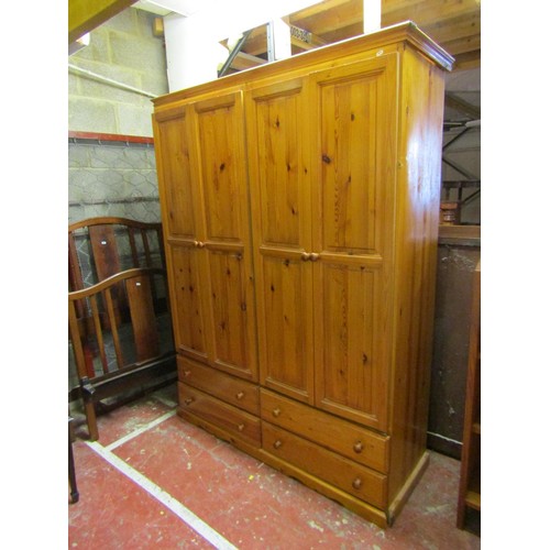 1509 - A pine wardrobe with two panelled doors over four drawers, 150cm wide