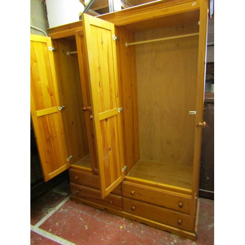 1509 - A pine wardrobe with two panelled doors over four drawers, 150cm wide