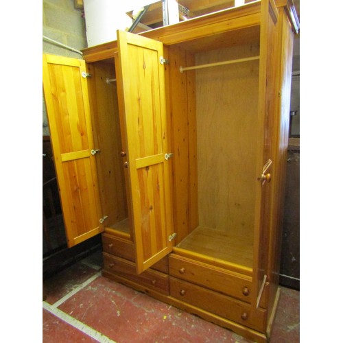 1509 - A pine wardrobe with two panelled doors over four drawers, 150cm wide