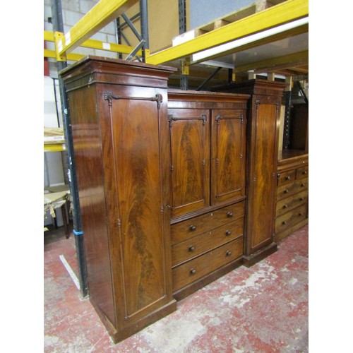 1514 - An Victorian flamed mahogany inverted breakfront triple wardrobe enclosed by a series of cupboards, ... 