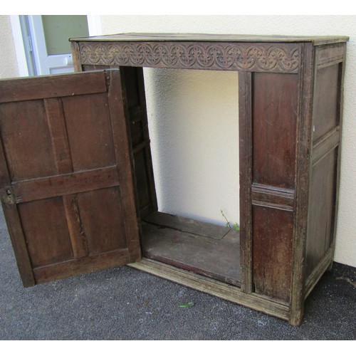 1533 - An old English oak sideboard, with shallow carved frieze above a single hinged panelled door with fl... 