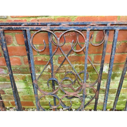 1027 - A pair of heavy gauge ironwork driveway entrance gates, with vertical open square rails flanking cen... 