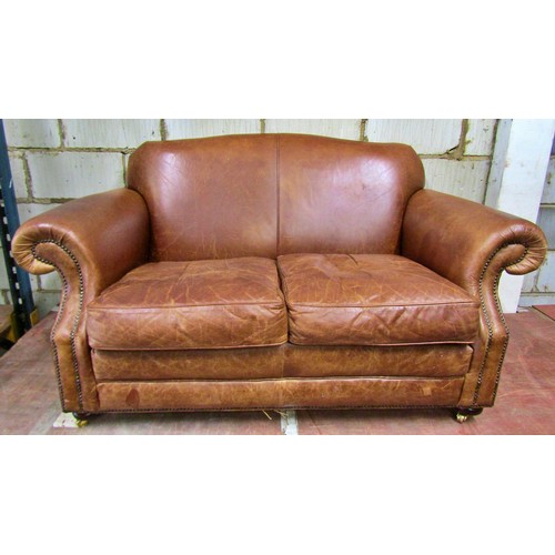 1494 - A small traditional leather two seat sofa with scrolled arms, 150cm wide